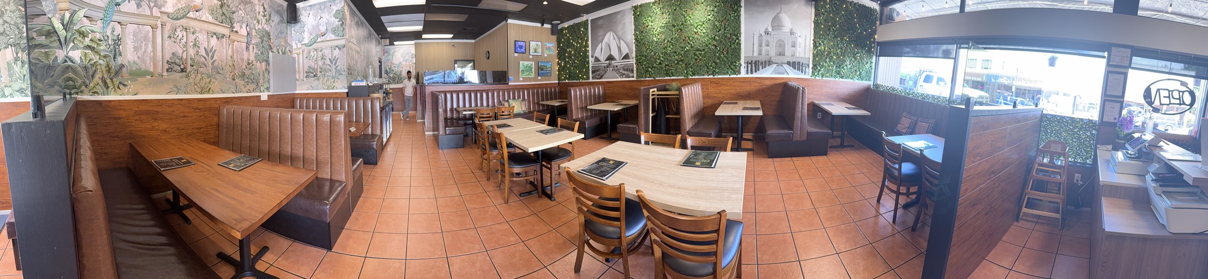 Inside 4 Seasons Chaat House — warm wood paneling, lush greenery and Taj Mahal mural